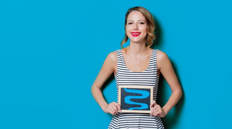 Lächende Frau hält Tafel mit blauer Darm-Illustration vor blauem Grund.