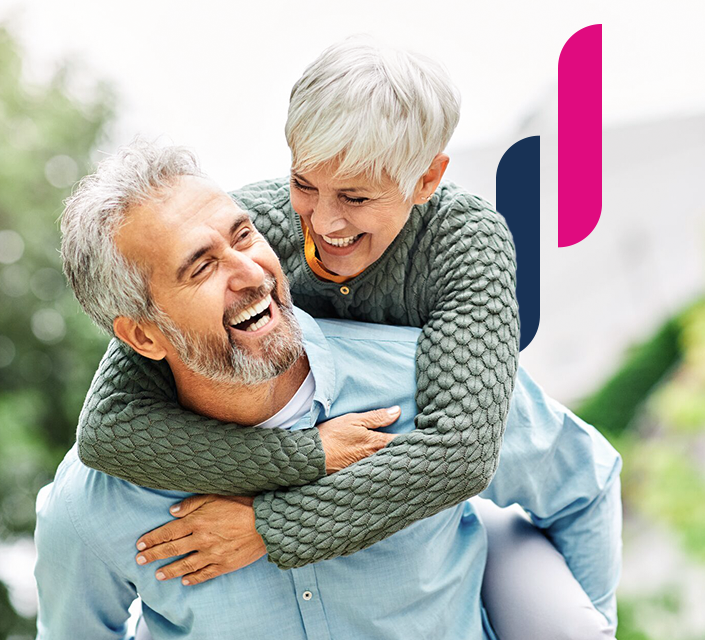 Aktives, glückliches Seniorenpaar lachend huckepack in einem Park.